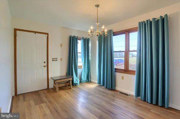 a view of a room with wooden floor and a window