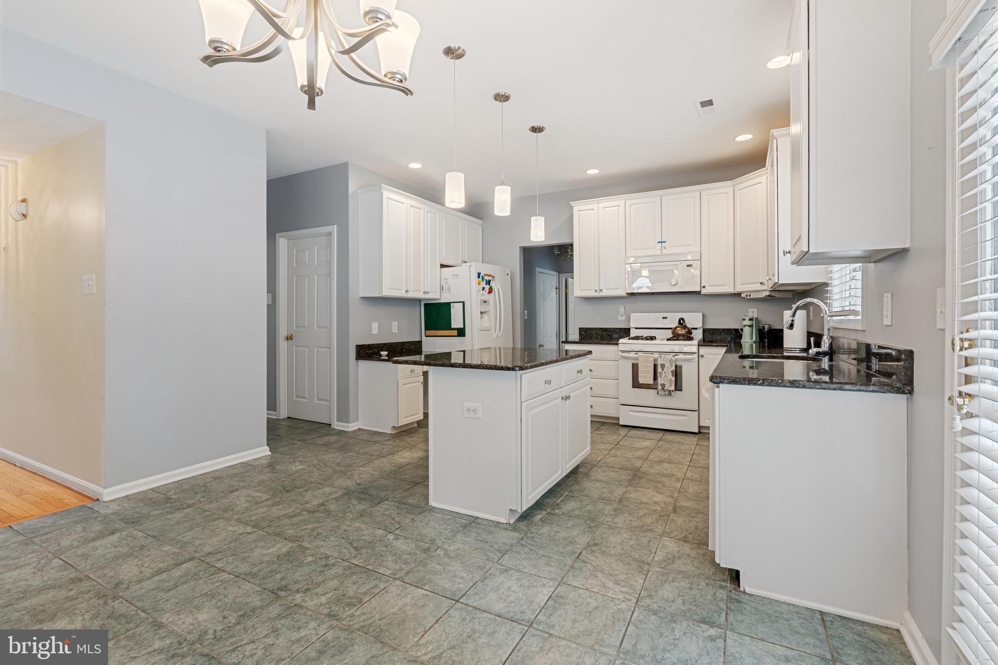 4913 Mead Drive Doylestown, PA 18902 - Photo 10 of 41 a kitchen with kitchen island granite countertop a stove a sink a refrigerator and white cabinets