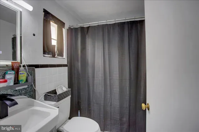 a bedroom with bed and a refrigerator