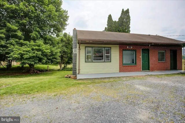 a view of a house with a big yard and large trees