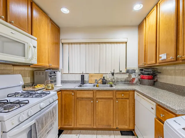 a kitchen with a sink stove top oven and cabinets