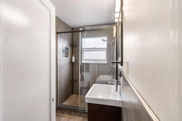 a bathroom with a sink a toilet and shower