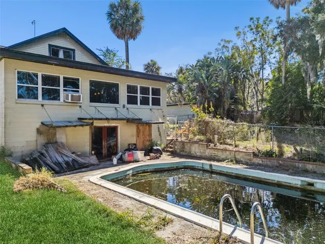 a view of a house with pool and chairs