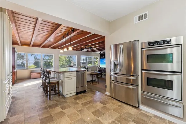 a kitchen with a refrigerator and wooden cabinets