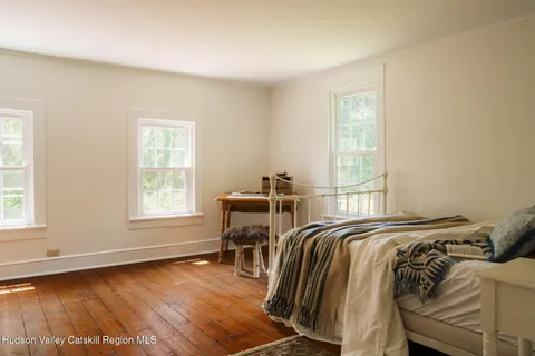a bed sitting in a bedroom next to a window