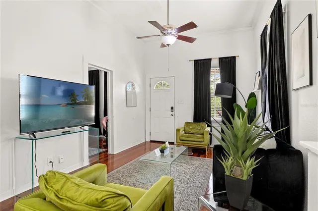 a living room with furniture floor to ceiling window and a flat screen tv