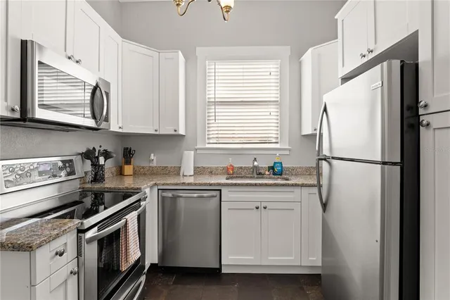 a kitchen with white cabinets and white appliances