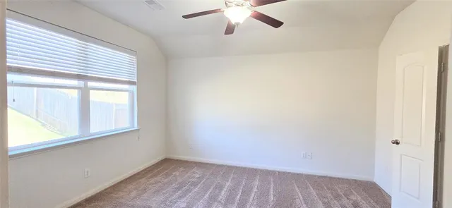 an empty room with a window and a ceiling fan