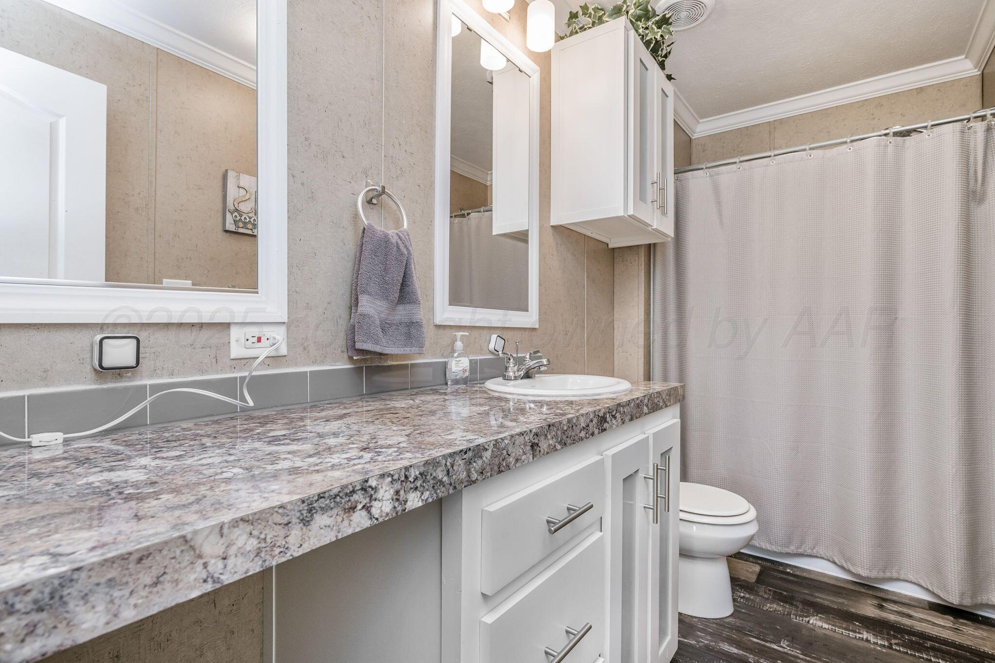 441 West Plantation Road Amarillo, TX 79118 - Photo 16 of 25 a bathroom with a granite countertop sink and a mirror