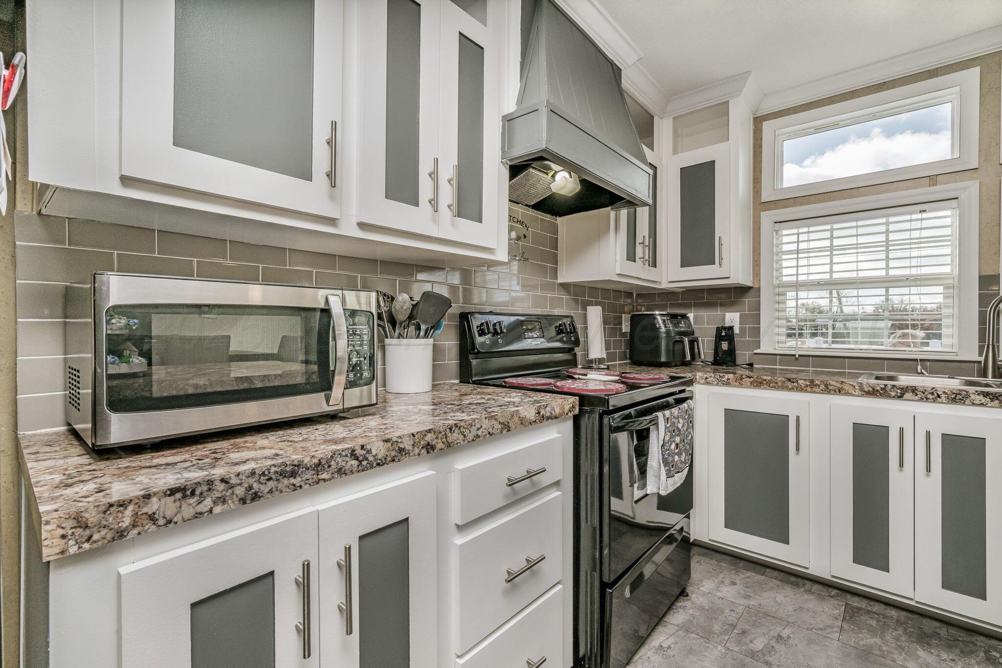 441 West Plantation Road Amarillo, TX 79118 - Photo 6 of 25 a kitchen with stainless steel appliances granite countertop a stove microwave and cabinets