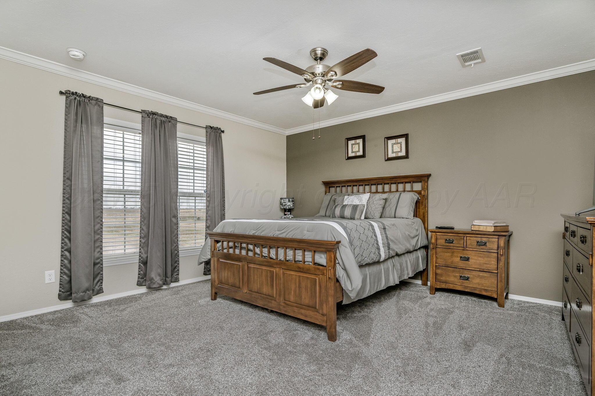 441 West Plantation Road Amarillo, TX 79118 - Photo 9 of 25 a spacious bedroom with a bed and a chandelier