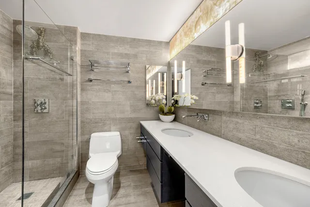 a bathroom with a sink a toilet and shower