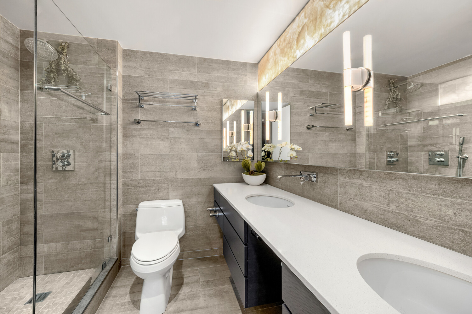 641 5th Avenue, Unit 34B Manhattan, NY 10022 - Photo 10 of 12 a bathroom with a sink a toilet and shower