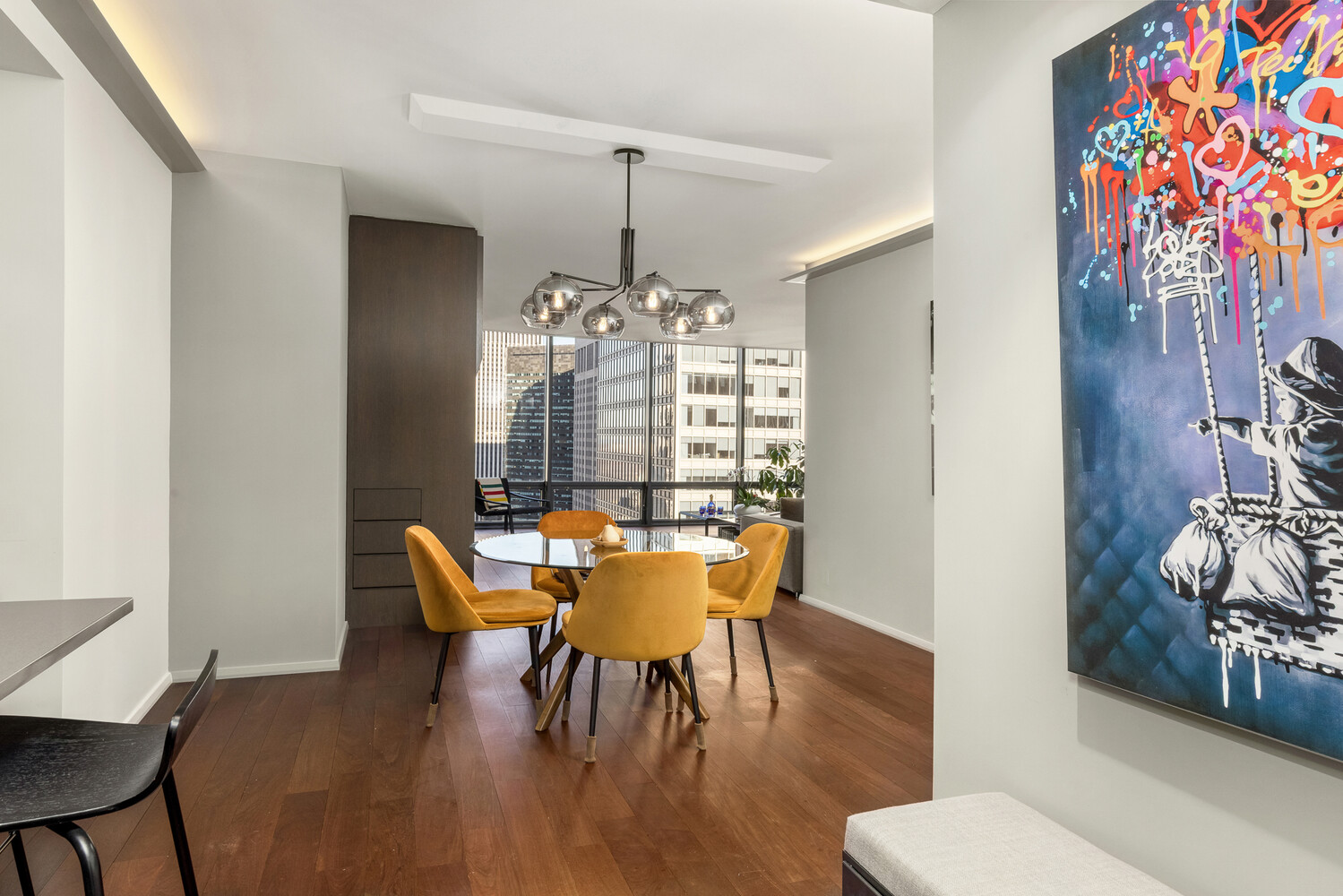 641 5th Avenue, Unit 34B Manhattan, NY 10022 - Photo 5 of 12 a dining room with furniture a chandelier and wooden floor