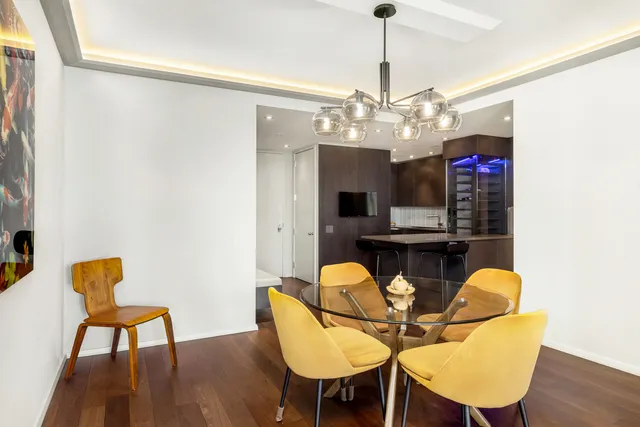 a dining room with furniture a chandelier and wooden floor