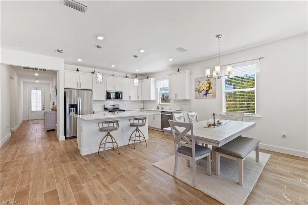 15850 Blue Rdg Way Punta Gorda, FL 33982 - Photo 5 of 23 a kitchen with stainless steel appliances kitchen island granite countertop a table chairs sink and cabinets