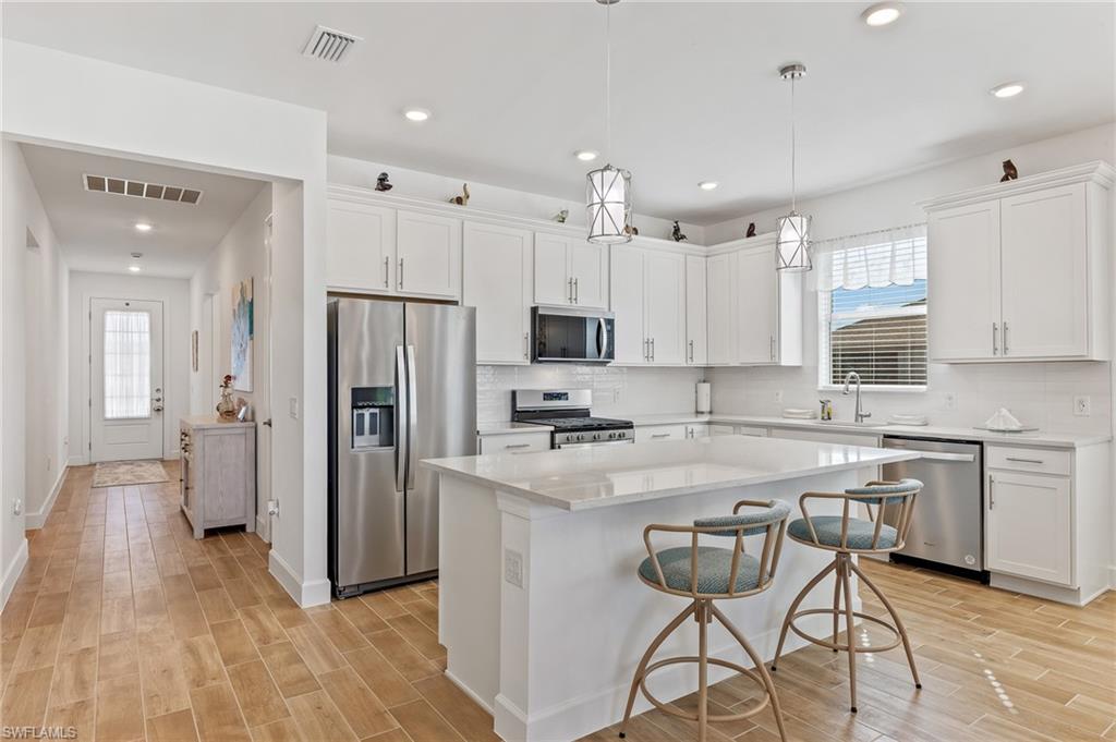15850 Blue Rdg Way Punta Gorda, FL 33982 - Photo 6 of 23 a kitchen with stainless steel appliances granite countertop a refrigerator a sink dishwasher a stove and white cabinets with wooden floor