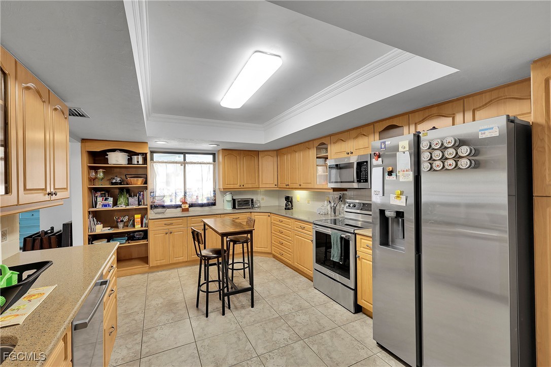 19165 Coconut Road Fort Myers, FL 33967 - Photo 7 of 27 a kitchen with stainless steel appliances granite countertop a refrigerator and a stove top oven