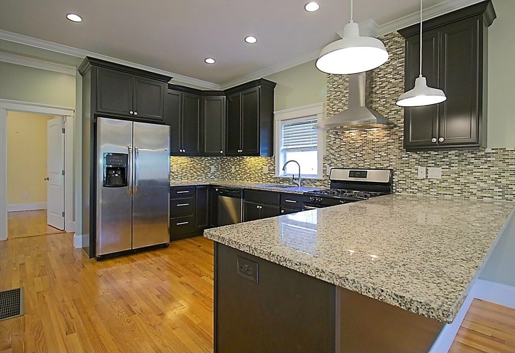 a kitchen with stainless steel appliances granite countertop a sink a refrigerator and a stove