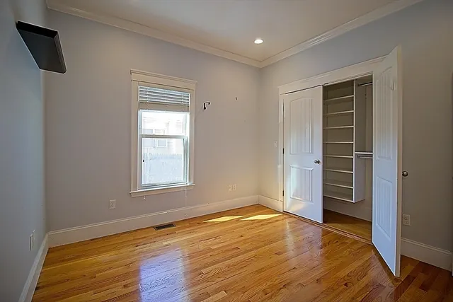 a view of an empty room with closet and a window