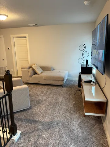 a living room with furniture pool table and wall painting
