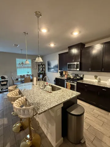 a kitchen with sink a counter and chairs