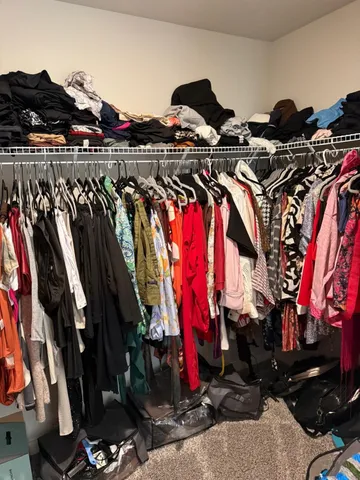 a view of walk in closet with clothes and shoes