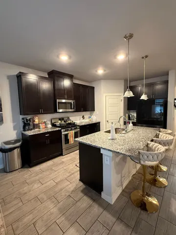 a large kitchen with kitchen island a sink counter space and stainless steel appliances
