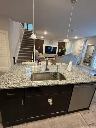 a kitchen with granite countertop a sink and a wooden cabinets