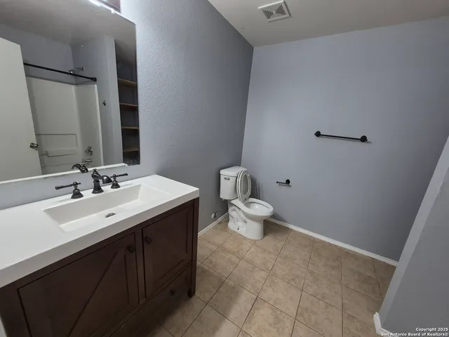 a bathroom with a toilet sink and mirror