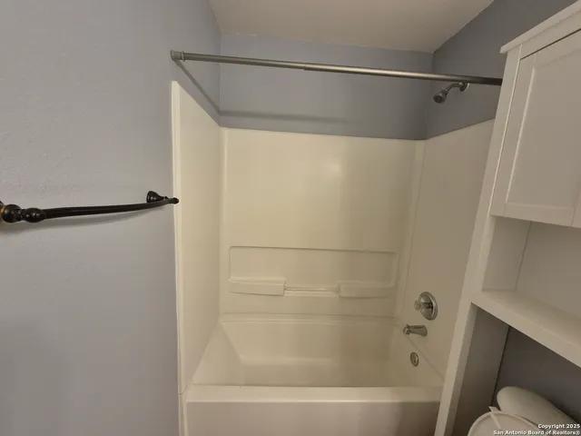 a bathroom with a shower and a bath tub