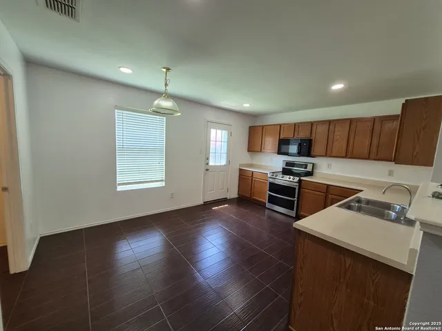 a kitchen with stainless steel appliances granite countertop a sink stove and refrigerator