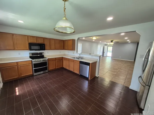 a kitchen with stainless steel appliances a stove a sink and a refrigerator