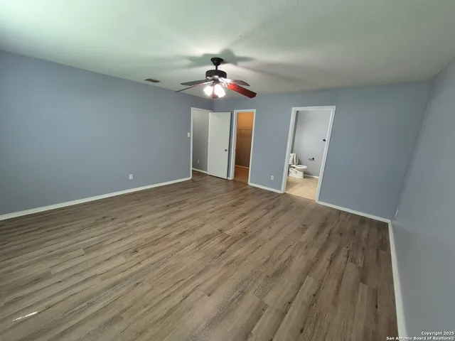a view of empty room with wooden floor