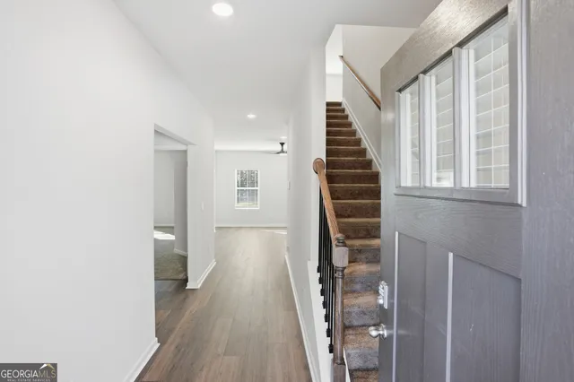 a view of a hallway with wooden floor and entryway