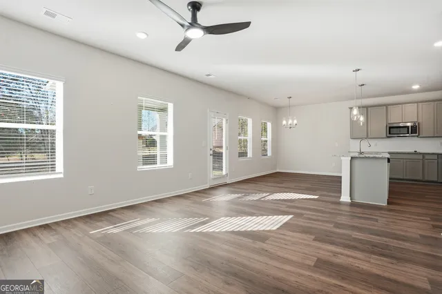 a view of an empty room with window and wooden floor