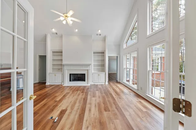 a view of a livingroom with a ceiling fan window and wooden floor