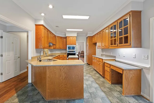 a kitchen with stainless steel appliances granite countertop a sink a stove and a refrigerator