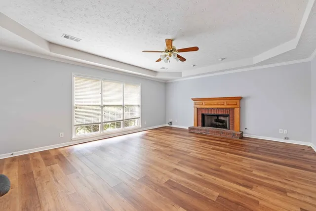 a view of empty room with wooden floor and fireplace