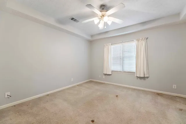 an empty room with a window and a ceiling fan