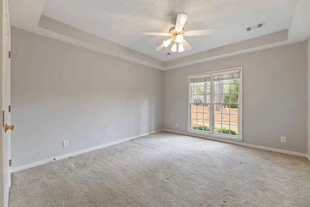 an empty room with chandelier fan