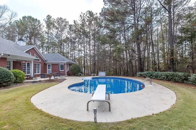 a swimming pool with outdoor seating and yard
