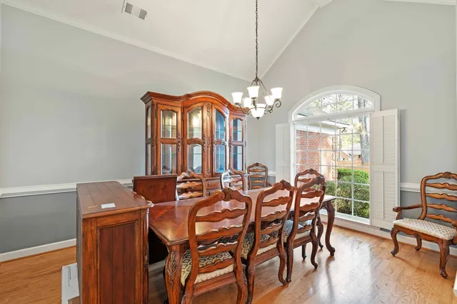 a view of a dining room with furniture a chandelier and wooden floor