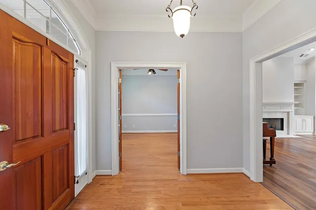 a view of a hallway with wooden floor and staircase
