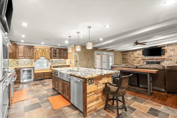 a open kitchen with stainless steel appliances granite countertop a stove top oven dining table and chairs