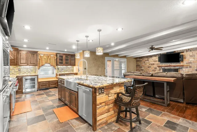 a open kitchen with stainless steel appliances granite countertop a stove top oven dining table and chairs