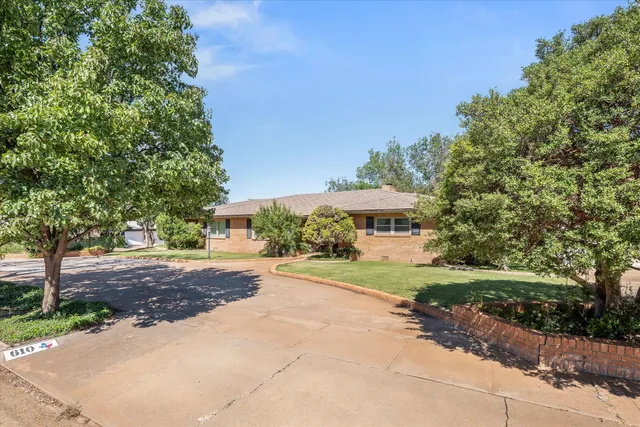 a view of a house with a yard and street
