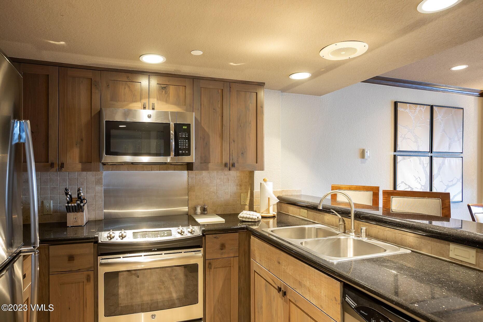 210 Offerson Road, Unit R214 WEEK 36 Beaver Creek, CO 81620 - Photo 6 of 19 a kitchen with a sink and a stove top oven with wooden floor