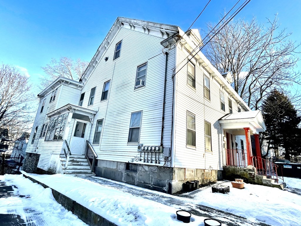 68 Smith Street Lowell, MA 01851 - Photo 2 of 24 a front view of a house with a yard