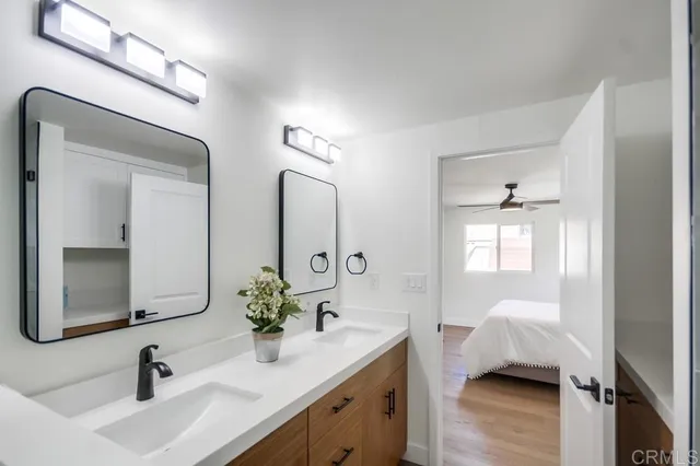 a en suite bathroom with a granite countertop sink and a mirror